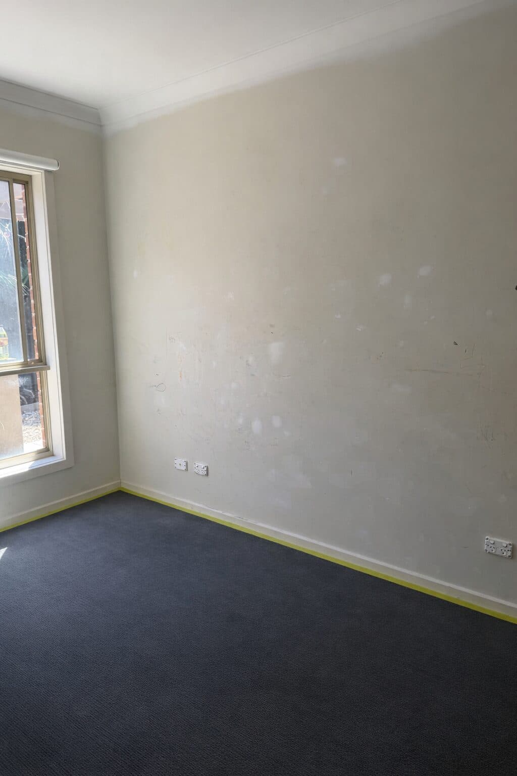 Before — scuffed and marked interior bedroom wall with old paint in a VIC home, prepped with masking tape by VD Painting