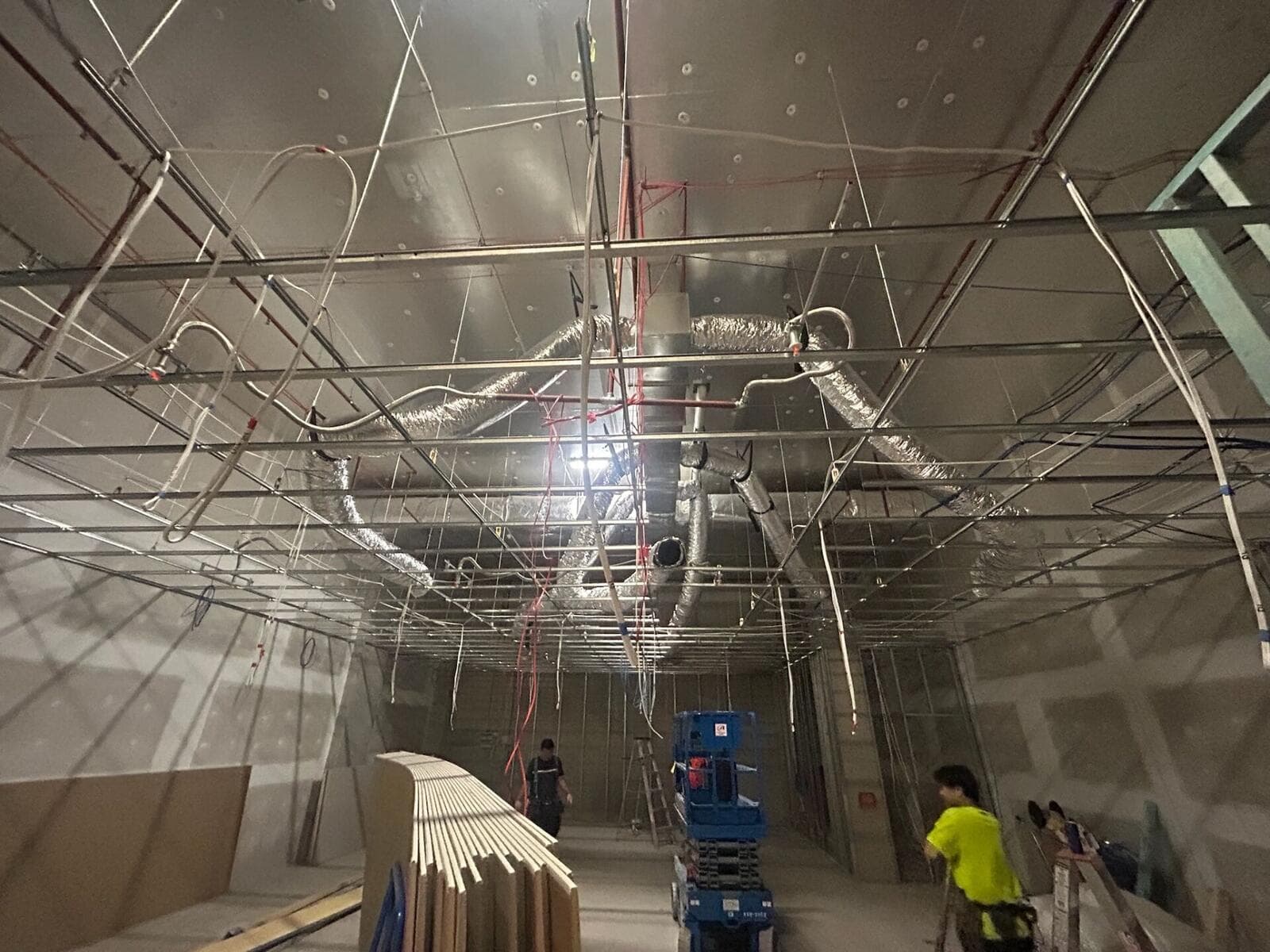 Commercial interior preparation — ceiling grid, ducting, and wall finishing underway before painting. VD Painting coordinates with site teams to achieve premium results