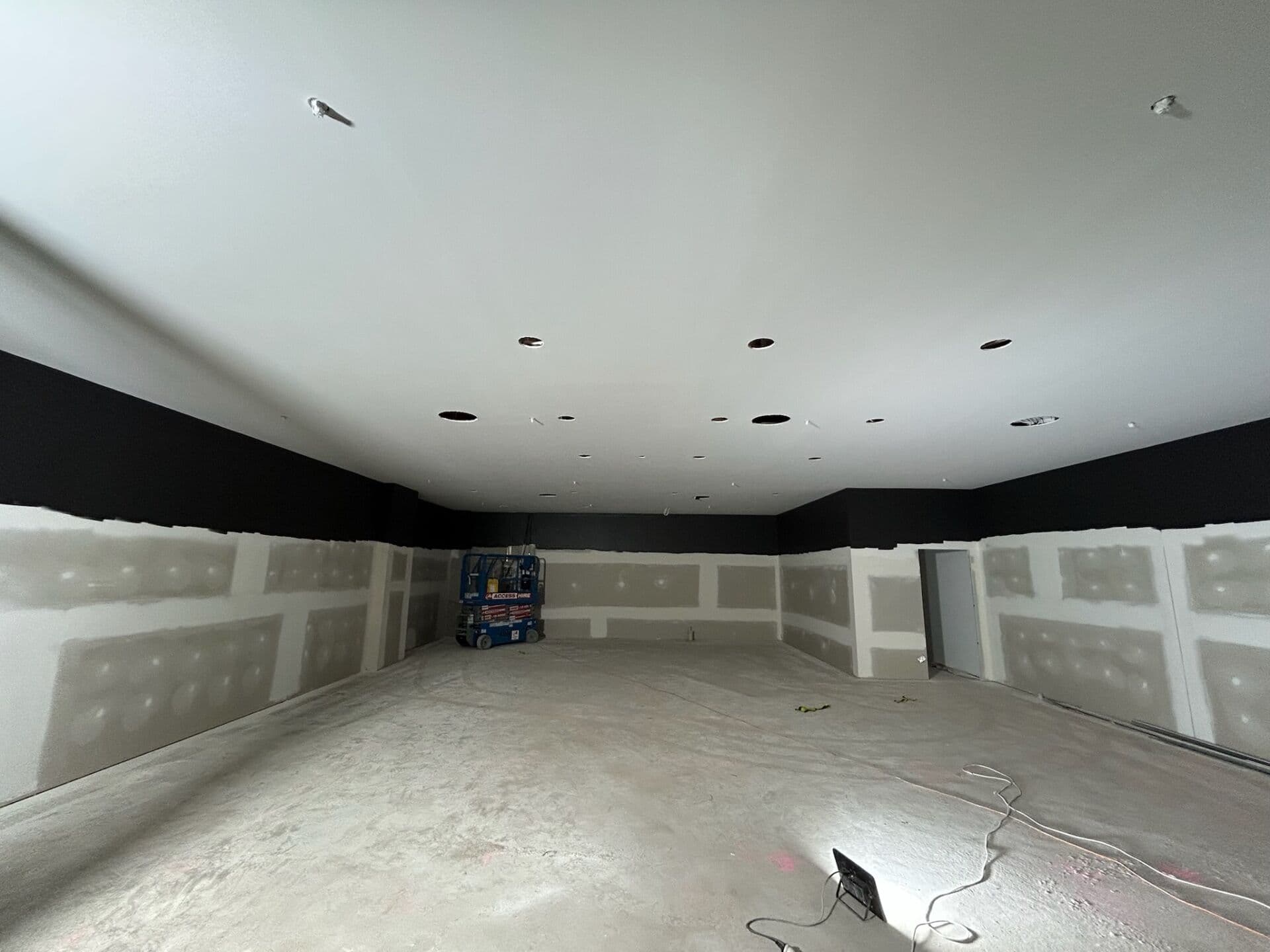 Completed commercial interior painting with smooth plasterboard walls, black upper feature section, and finished ceilings by VD Painting.